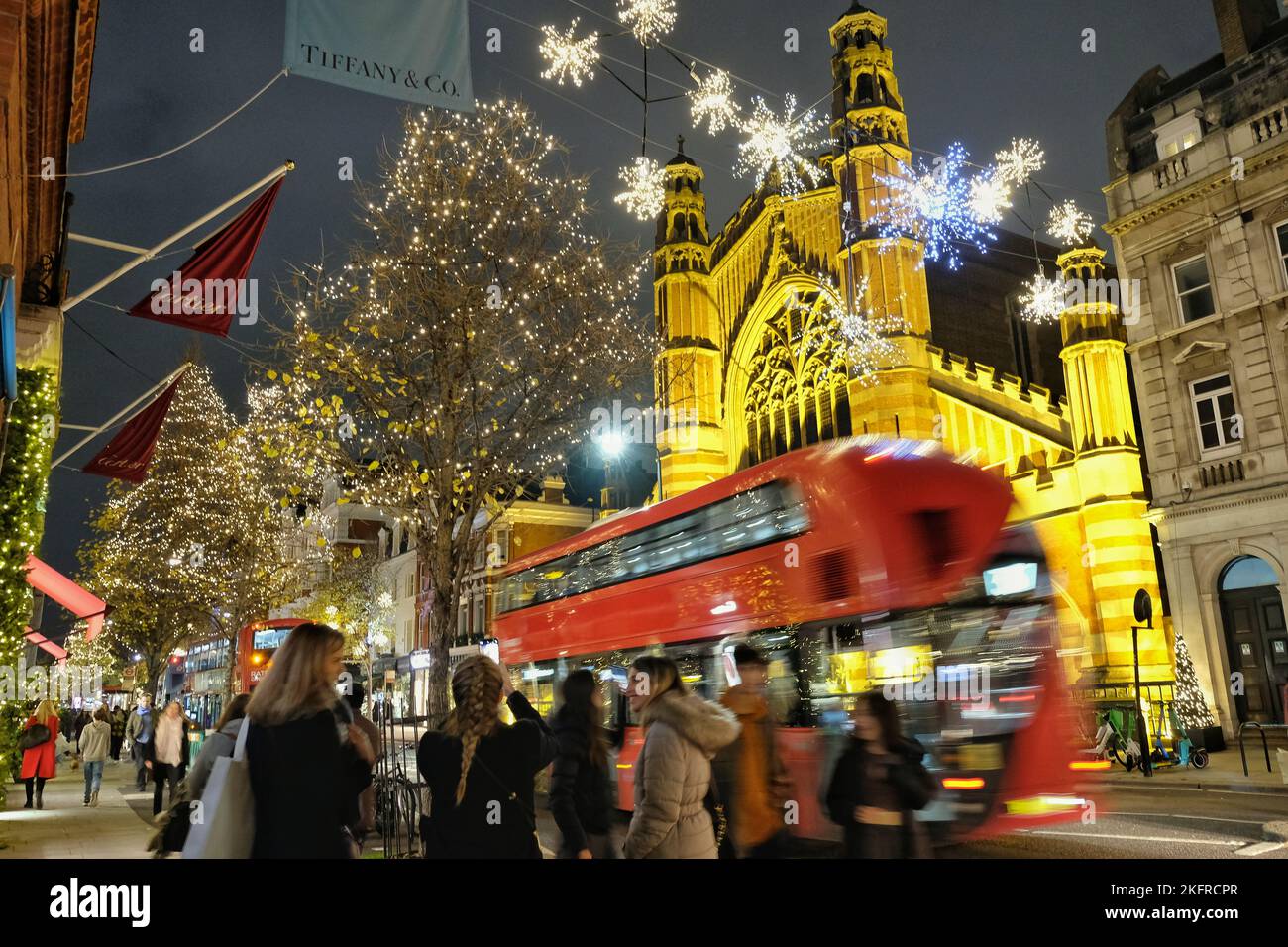 London, UK. 19th November, 2022. Buses pass Sloane Street with Christmas lights glittering behind. The Christmas light switch-on in King's Road attracted huge numbers of visitors to the surrounding area as people enter into the festive spirit. Credit: Eleventh Hour Photography/Alamy Live News Stock Photo