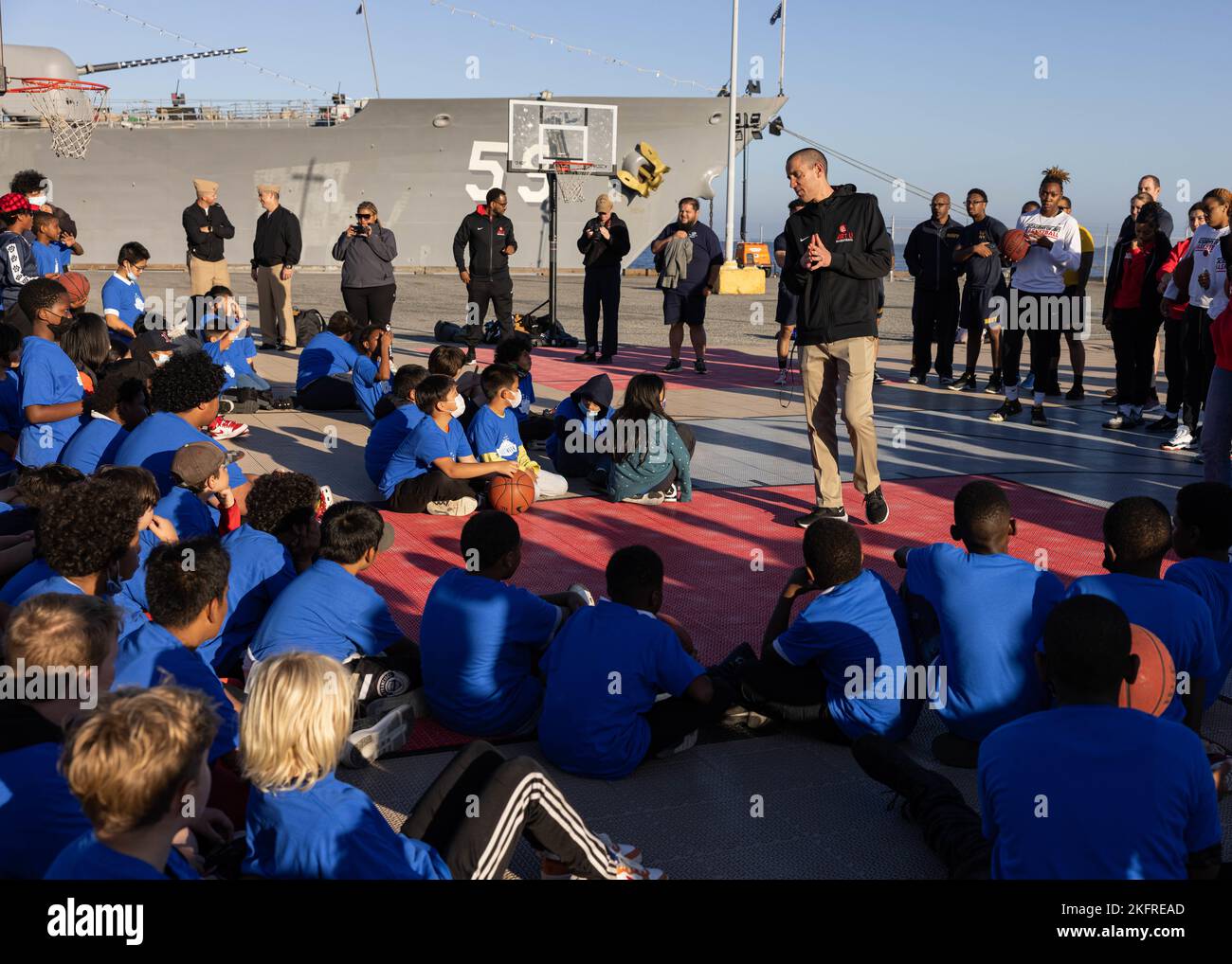 221004-M-VR919-1046 SAN FRANCISCO (October 4, 2022) Scott Waterman, men’s basketball head coach for Academy of Art University, speaks to the children from the Boys and Girls Club of San Francisco about the rules of the Hoops with the Troops event at the Port of San Francisco, California, Oct. 4, 2022. SFFW is an opportunity for the American public to meet their Navy, Marine Corps and Coast Guard teams and experience America’s sea services. During fleet week, service members participate in various community service events, showcase capabilities and equipment to the community, and enjoy the hosp Stock Photo