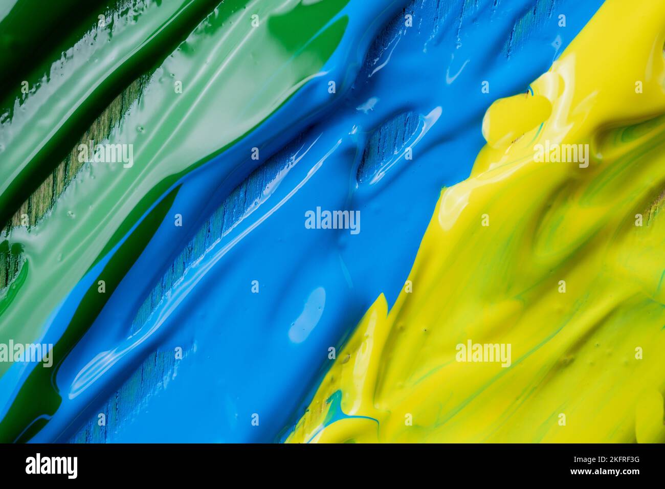 A closeup shot of green blue and yellow oil paint swiped on a canvas Stock Photo