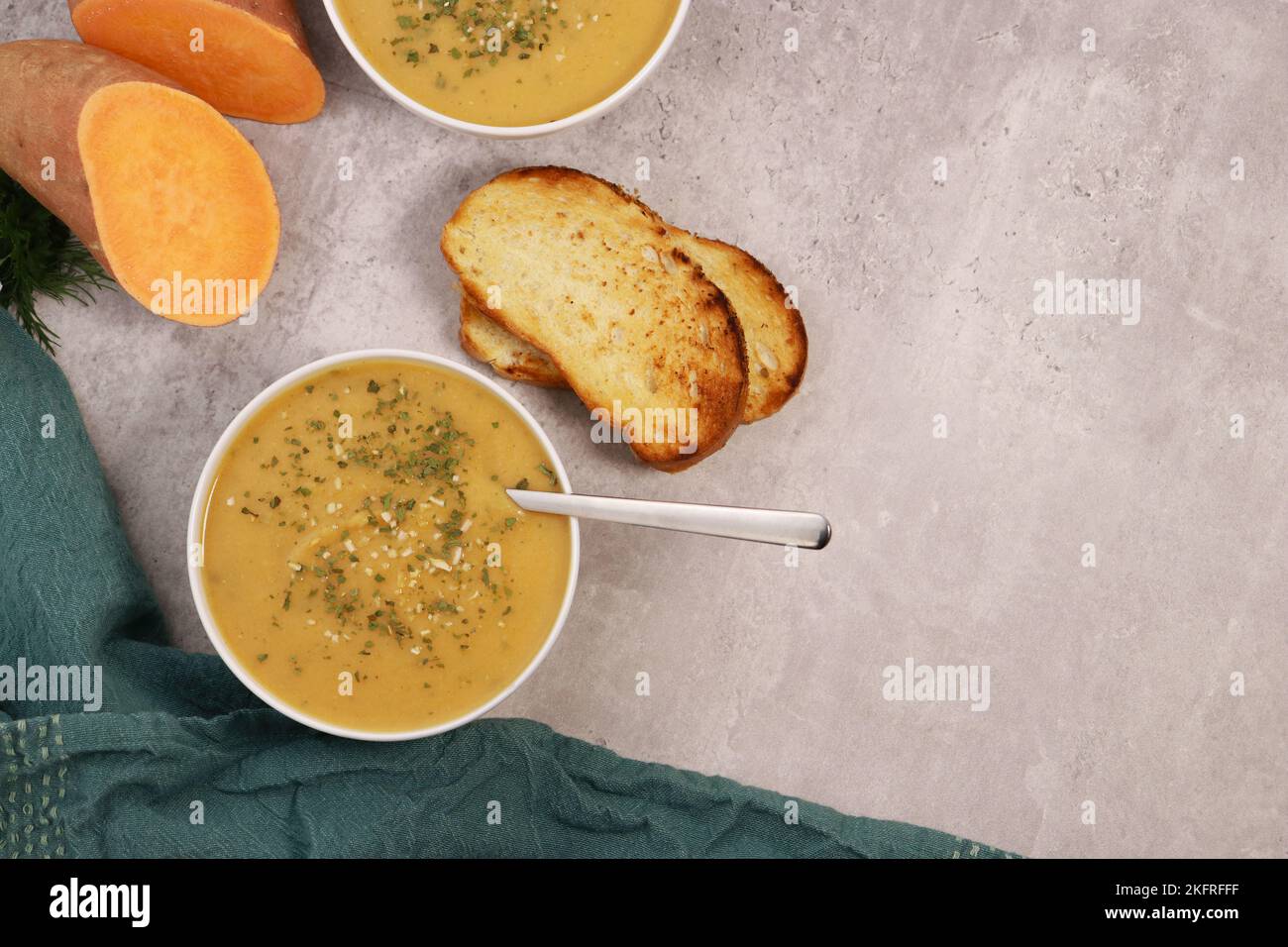 sweet potato puree soup with garlic bread on grey marble table Stock