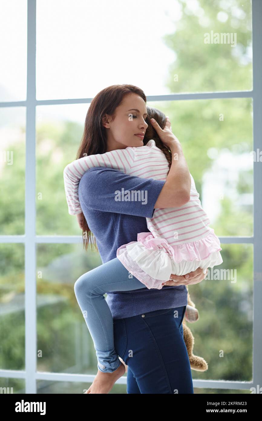 Tender love. a mother lovingly embracing her daughter at home. Stock Photo