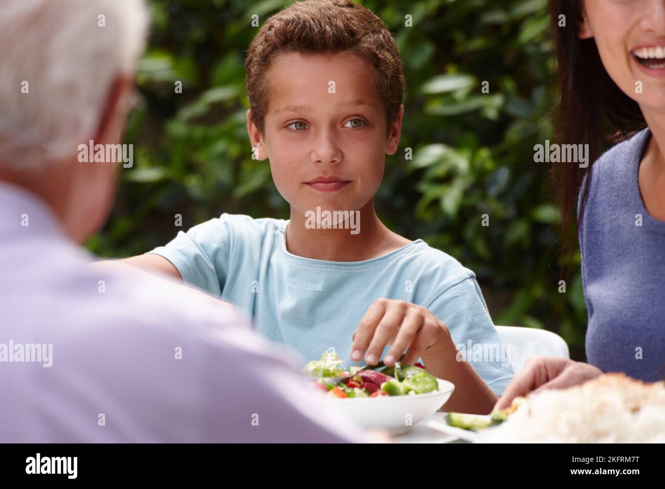 Food and family. a little boy having lunch with his family outside. Stock Photo