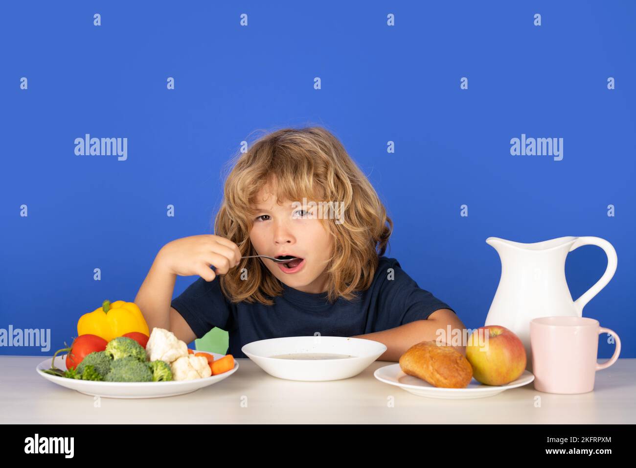 Healthy breakfast lunch for kids. Little kid boy have a dinner. Hungry face and enjoy eating enjoy food concept. Child eating soup. Young boy with Stock Photo