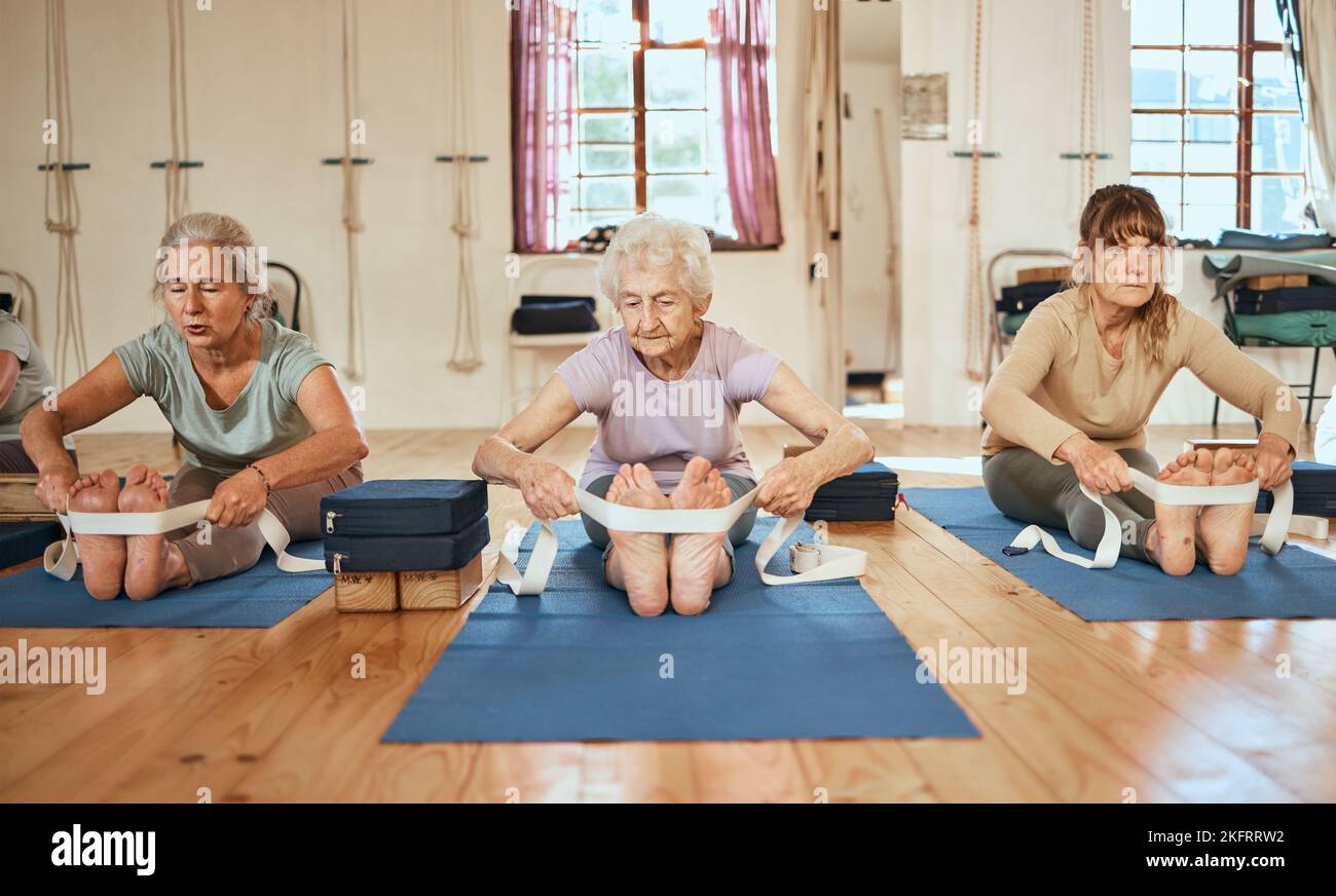Senior, yoga stretching and leg band for wellness, training and exercise for health and gym wellness. Elderly workout and yoga class with pilates in a Stock Photo