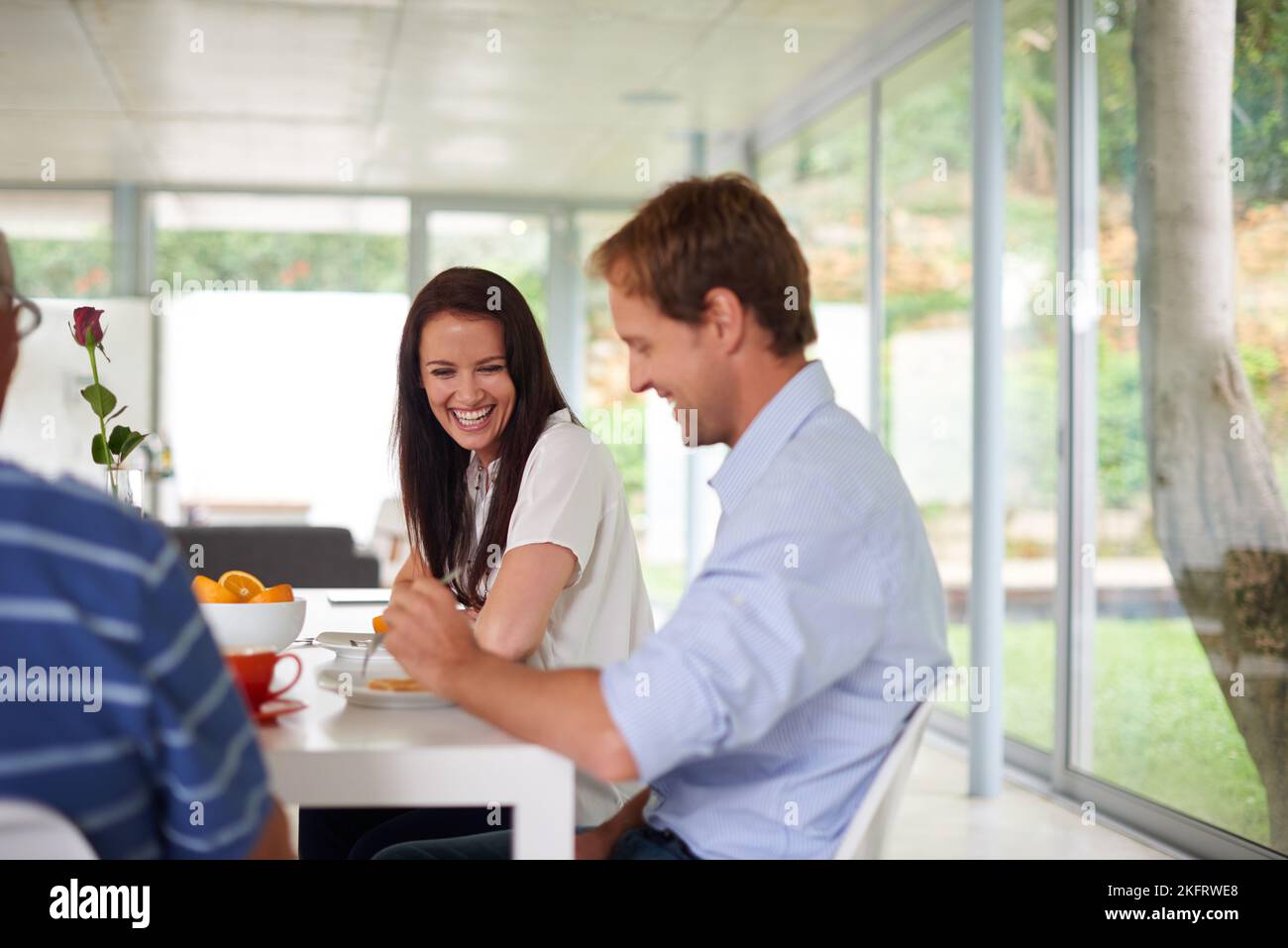 Morning laughter. a couple laughing while eating breakfast Stock Photo Alamy