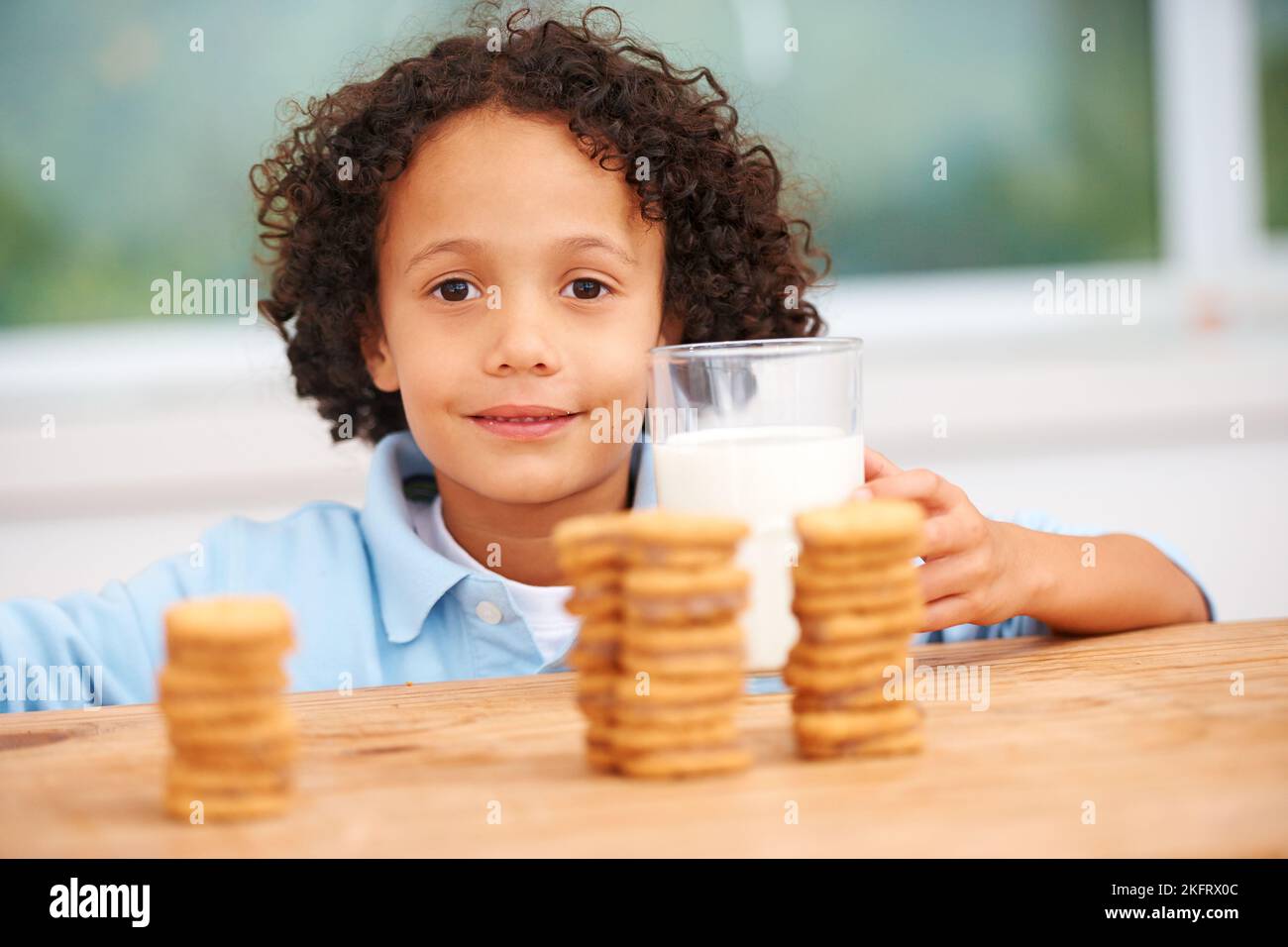 Mmm, so many cookies just for me. A cute young boy grabbing a cookie