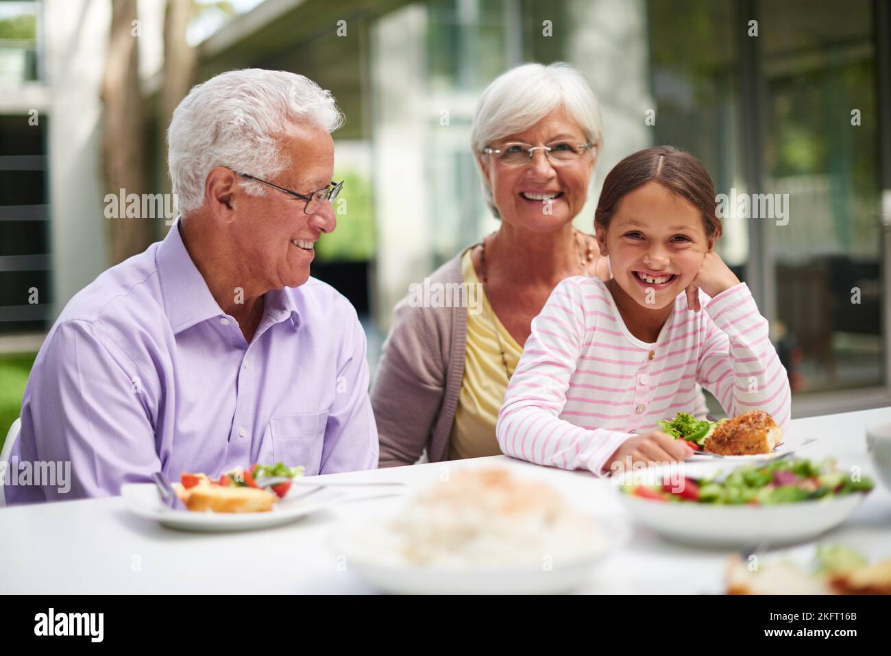 Lunch with Grandpa and Granny. a granddaughter sitting with her