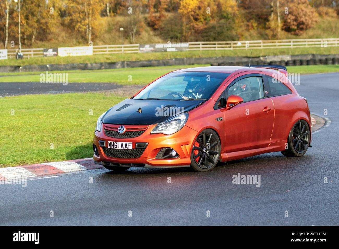 2012 Orange Vauxhall Corsa Vxr Nurburgring Edition 1.6T 205  hatchback petrol Car1598 cc; driving on challenging high-speed and technical low-geared corners of the Three sisters race circuit near Wigan, UK Stock Photo
