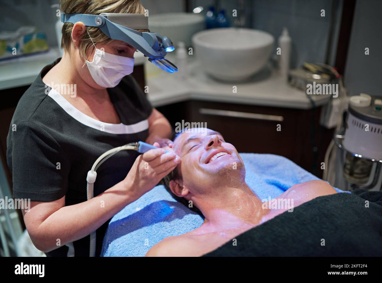 Modern beauty treatments for a younger-looking you. a man getting a non-invasive face lift at a beauty clinic. Stock Photo