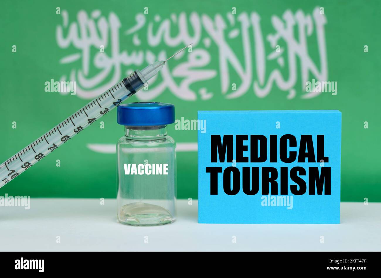 Medicine concept. Vaccine, syringe and blue plate with the inscription - MEDICAL TOURISM. In the background the flag of Saudi Arabia Stock Photo