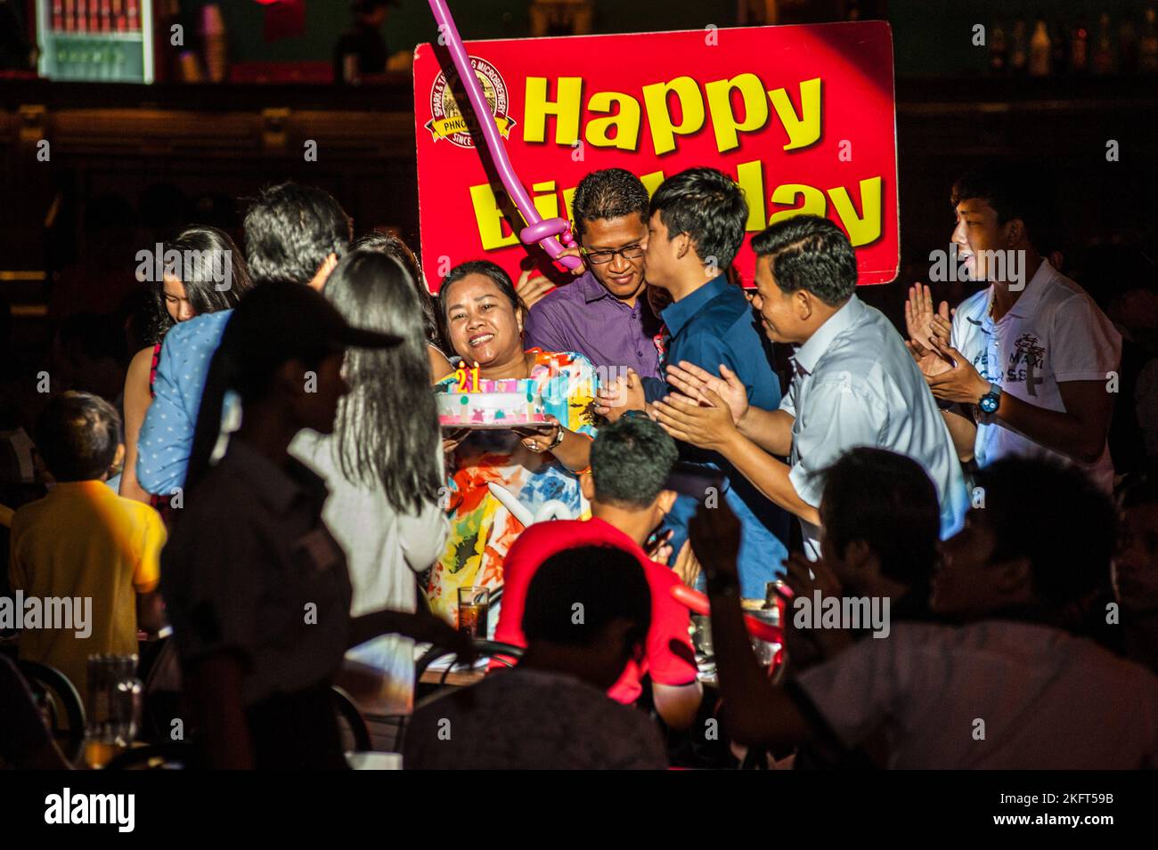 Happiness, Cambodian Birthday Party w/ birthday cake & sign, Spark & Tawandang German Brewery, Phnom Penh, Cambodia, Indochina. © Kraig Lieb Stock Photo