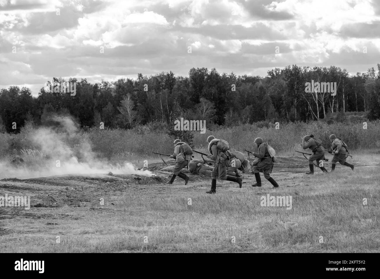 The attack of Soviet soldiers in the field, black and white. Smoke from guns. Reconstruction of the battle of World War II. Russia, Chelyabinsk region Stock Photo