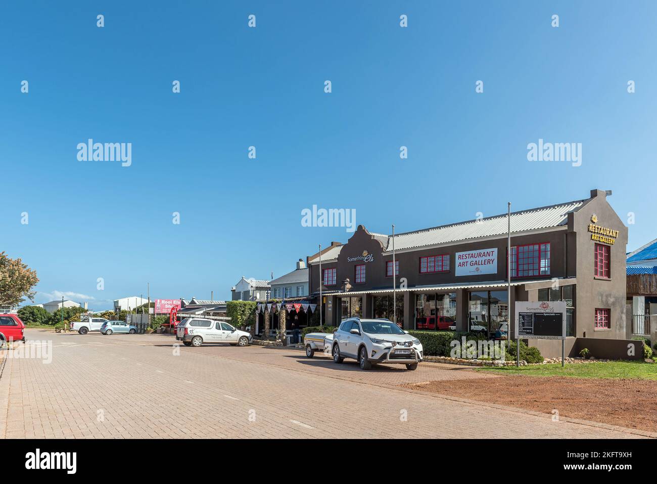 Rooiels, South Africa - Sep 20, 2022: A street scene in Rooiels in the Western Cape Overberg Region. A restaurant, art gallery and vehicles are visibl Stock Photo