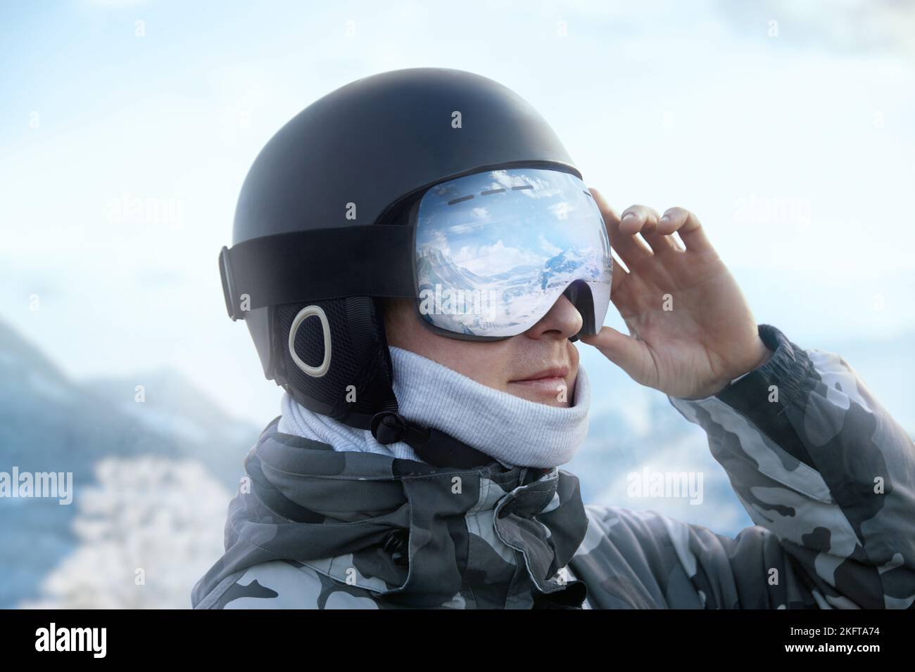 Close up of the ski goggles of a man with the reflection of snowed mountains. A mountain range reflected in the ski mask. Portrait of man at the ski r Stock Photo