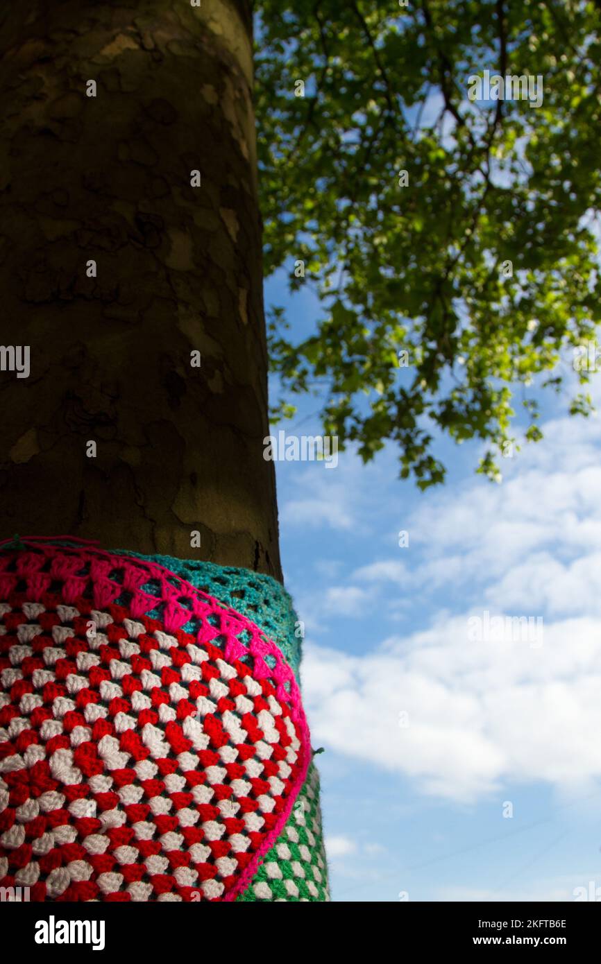 Yarn bombing (Tricot urbain in french) is  street art consisting in covering plants, trees, objects in streets or public places with decorative knitte Stock Photo