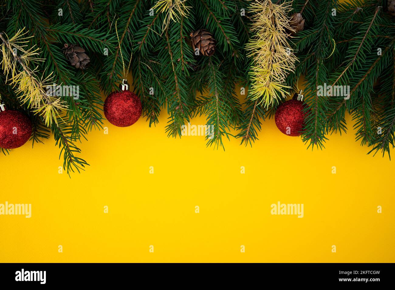 Christmas and New Year yellow background with fir border Stock Photo