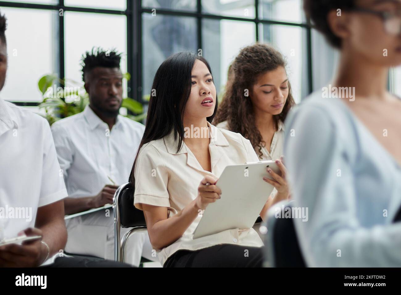 Millennial employees gathered in boardroom for training Stock Photo