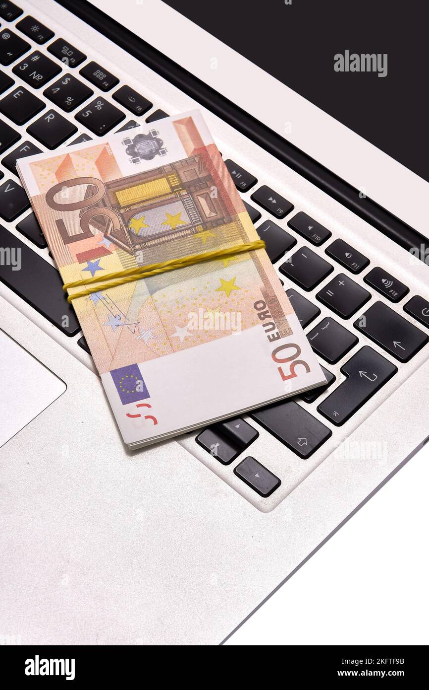 A bundle of 50 euro bills lying on a computer keyboard Stock Photo - Alamy