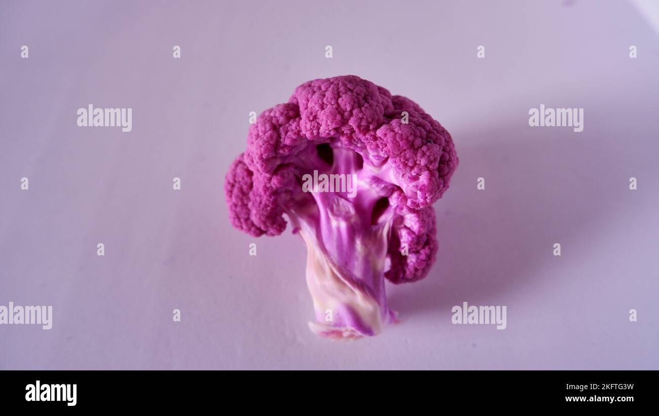 Piece of violet or purple or pink cauliflower like a tree on the white background, isolated, closeup. Stock Photo