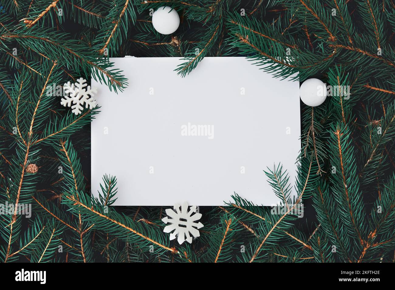 Creative layout made of Christmas tree branches with paper card note. Nature New Year concept. Stock Photo