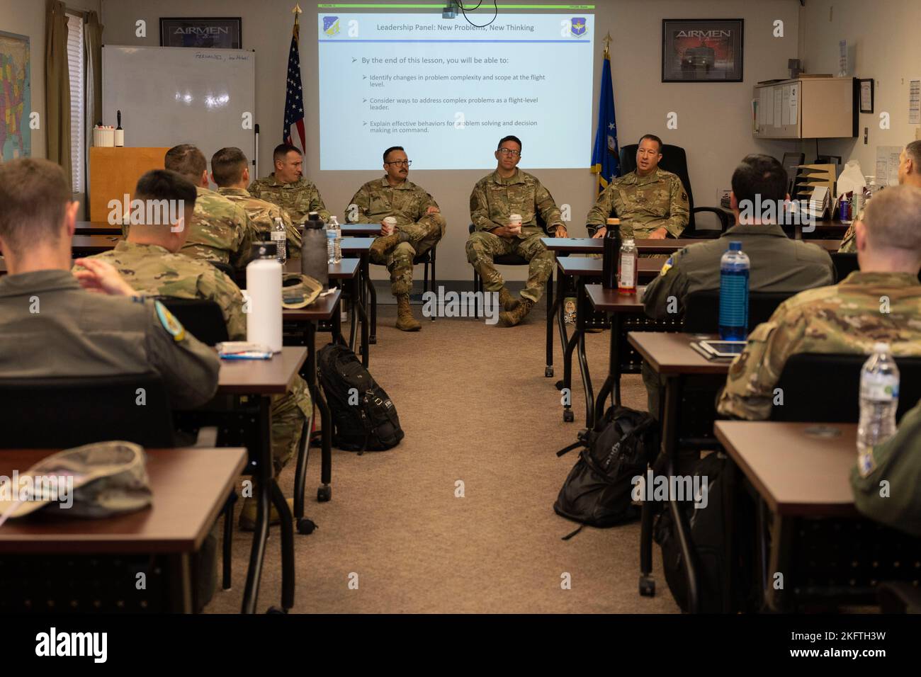 A panel of chief master sergeants speak to a class during a flight