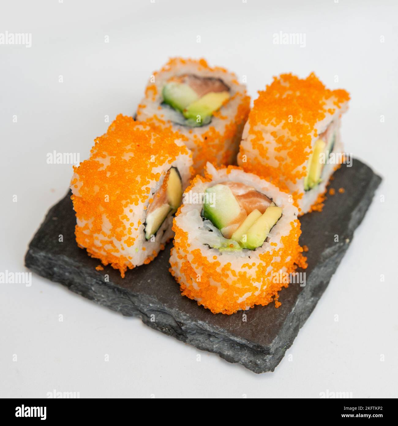 Traditional delicious fresh sushi roll set on black stone. California roll  with rice, crab meat cucumber, avocado. Masago (smelt roe) outside Stock  Photo - Alamy