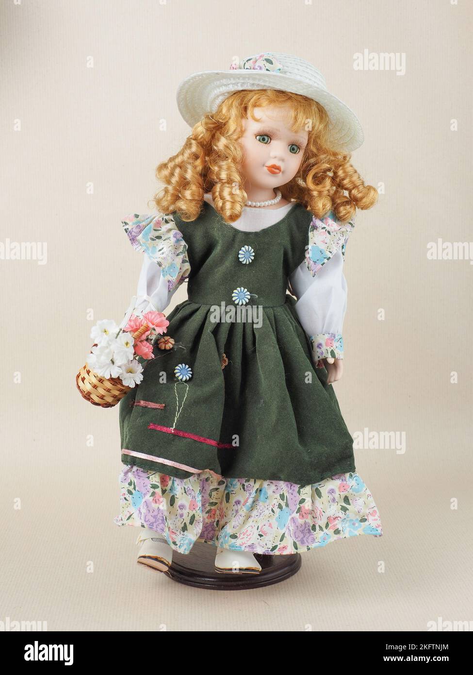 Germany. 19th Nov, 2022. In this photo illustration, a Vintage porcelain doll green-eyed red-haired girl with curls, pearl beads around her neck, in a green sundress and a white straw hat with a flower. Porcelain dolls were popular in the 18th century in France. They were used to promote French fashion in the world. Usually, such dolls were supplied with a large number of clothes and sent to customers as mini mannequins. (Photo by Igor Golovniov/SOPA Images/Sipa USA) Credit: Sipa USA/Alamy Live News Stock Photo