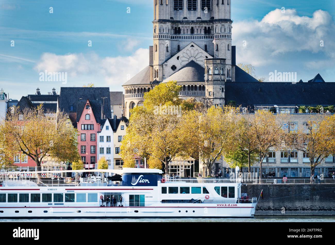 Cologne, Germany, November 2 2022: an excursion boat docks at the shore of the old town of cologne with autumnal colored trees Stock Photo