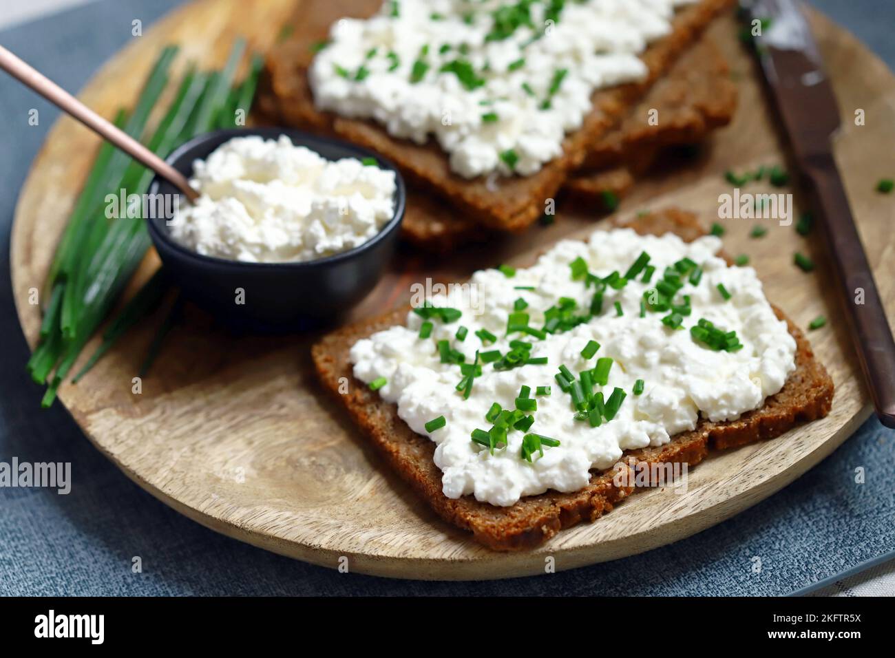 Open sandwiches with rye bread and white cottage cheese with green onions. Healthy breakfast or snack. Stock Photo