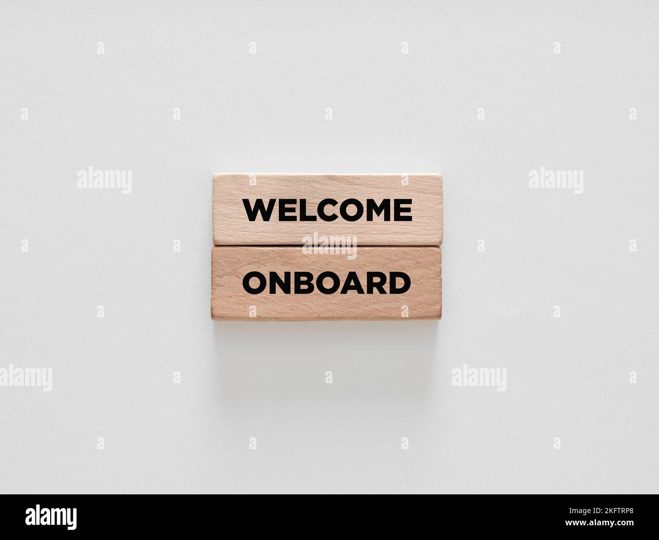 The message welcome onboard on wooden blocks on white background. Business support, teamwork and onboarding concept. Stock Photo