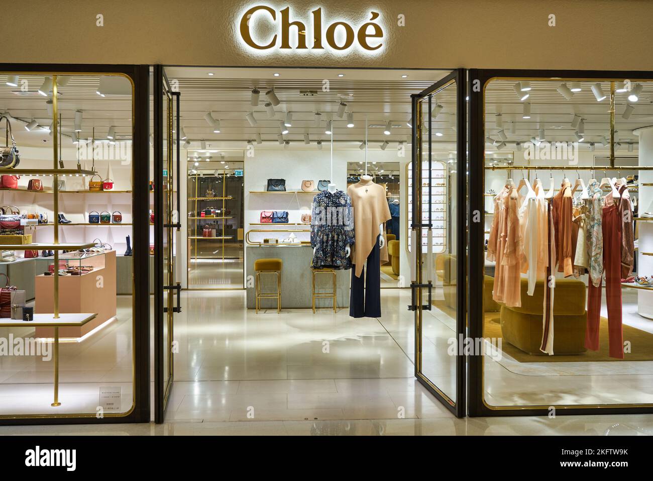 Shanghai/China-July 2019: close up bright shining Chloe logo on dark  exterior wall at night. Blurred store windows behind. Famous French fashion  luxury brand Stock Photo
