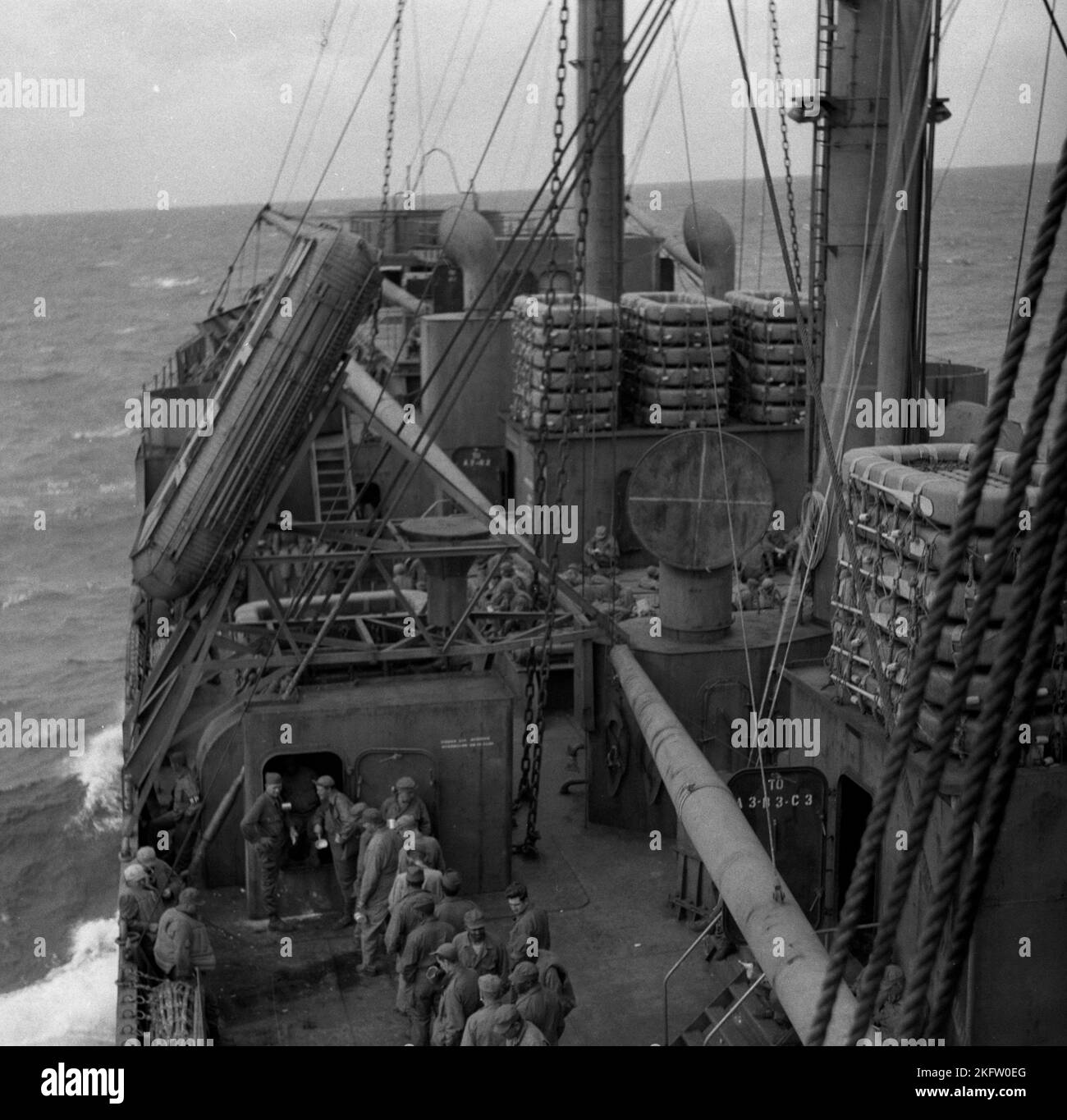 Men standing in line on deck of ship. United States Army veterans coming home on the Elgin Victory ship at the conclusion of World War II. SS Elgin Victory, a type VC2-S-AP2 Victory ship built by Permanente Metals Stock Photo
