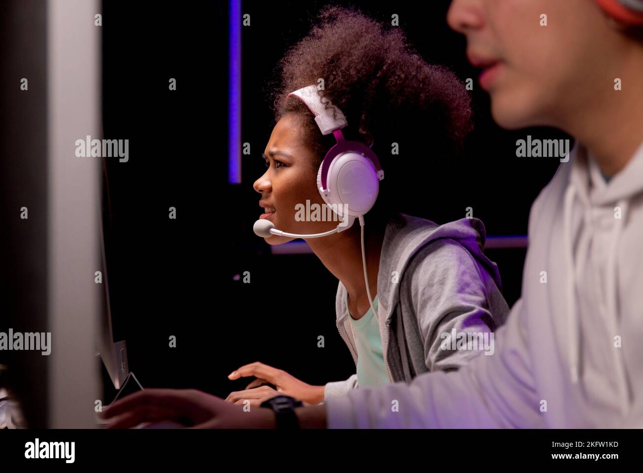 Young African American woman and asian man wearing headset play video game and live streaming online with microphone, gaming and esport for competitio Stock Photo