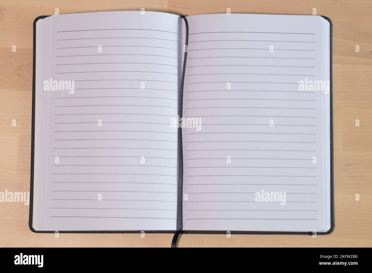 Empty lined notebook on wooden table. Ruled paper notebook Stock Photo