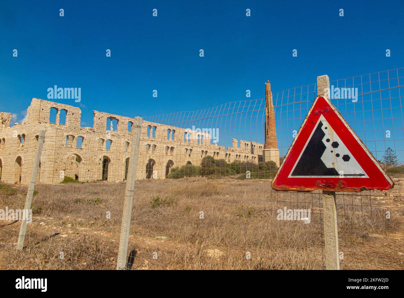 Fornace Penna, a deserted brick factory near Marina di Modica Sicily, Italy with a triangular warning sign of danger Stock Photo