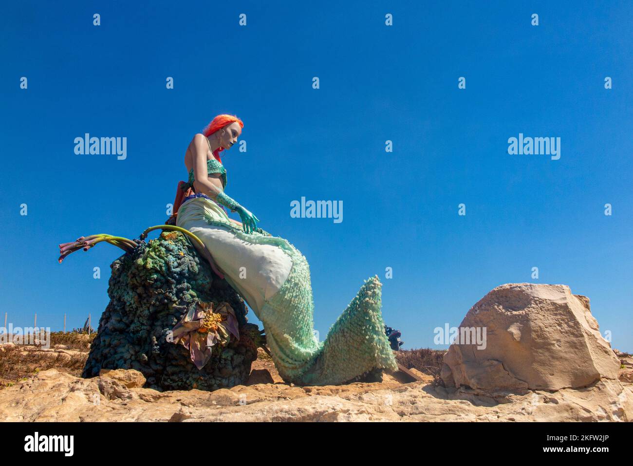 A mannequin mermaid looks out over the sea in Sicily, Italy Stock Photo