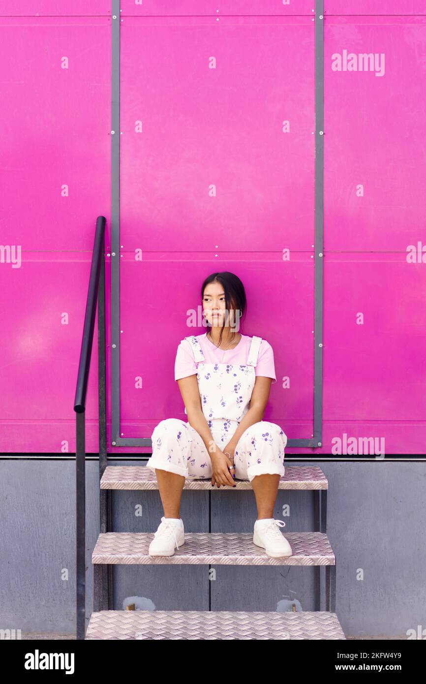 Calm Asian female near pink wall Stock Photo