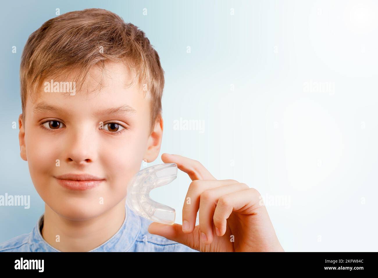 Boy is wearing orthodontic silicone trainer or nightguard case Stock