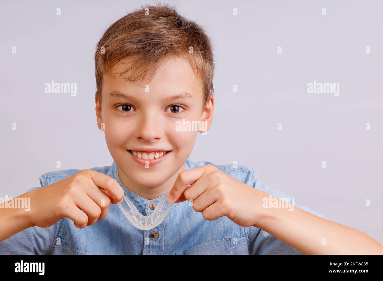 Boy is wearing orthodontic silicone trainer or nightguard case Stock