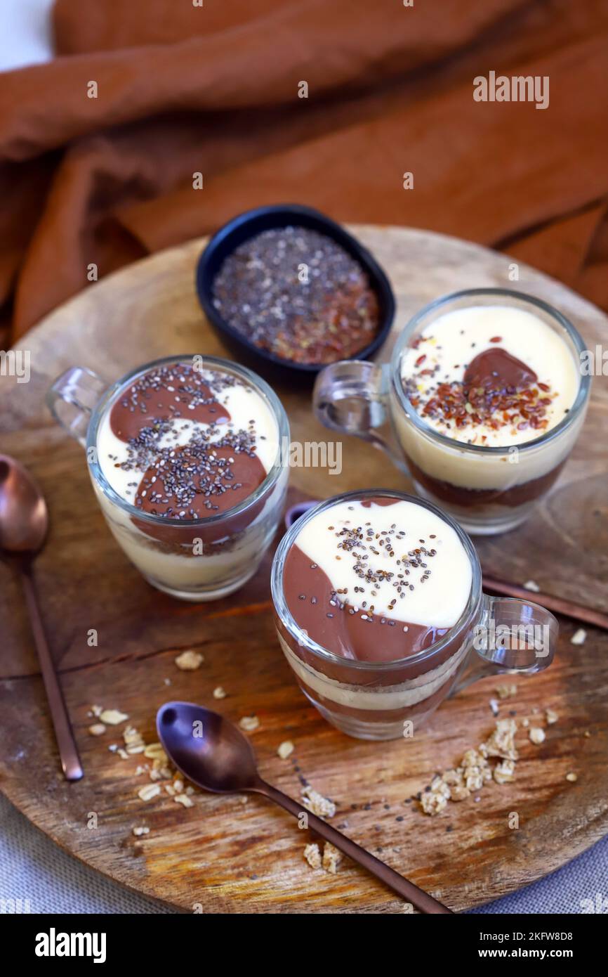 Healthy desserts in mugs. Vanilla and chocolate puddings with chia seeds and linseeds. Stock Photo