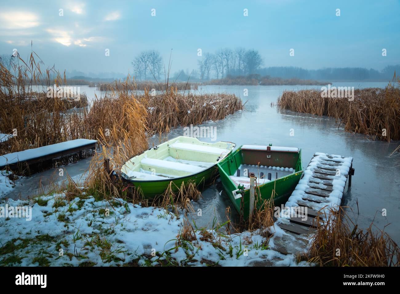 Small boats on the shore of a frozen lake Stock Photo