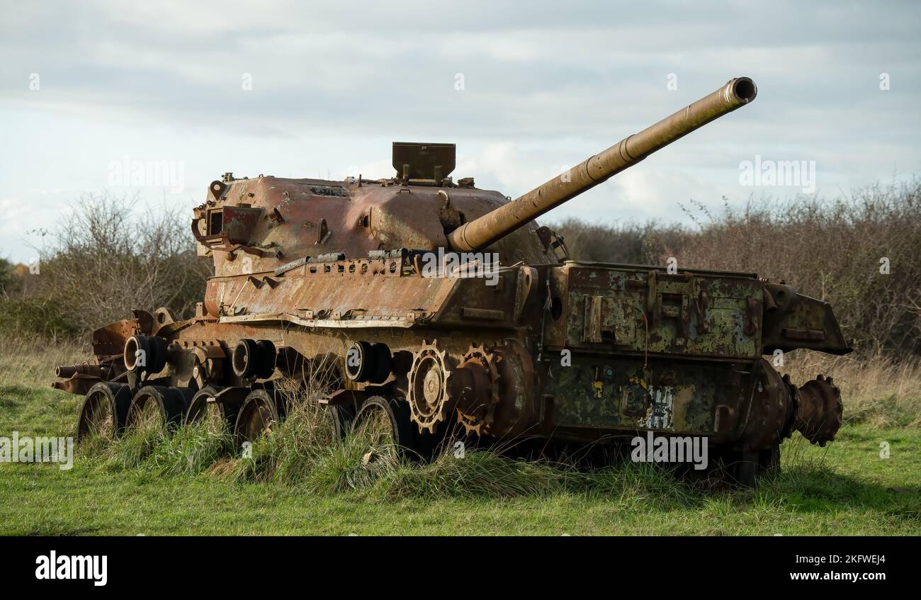 an abandoned rusting British FV4201 Chieftain main battle tank wreck in afternoon sunlight Stock Photo