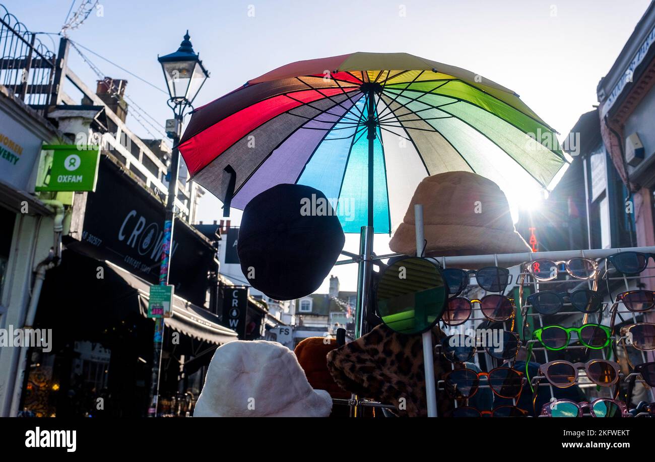 Brighton UK 20th November 2022 - A brightly coloured umbrella at a stall as The North Laine area of Brighton is busy with Christmas shoppers on a beautiful sunny day : Credit Simon Dack / Alamy Live News Stock Photo