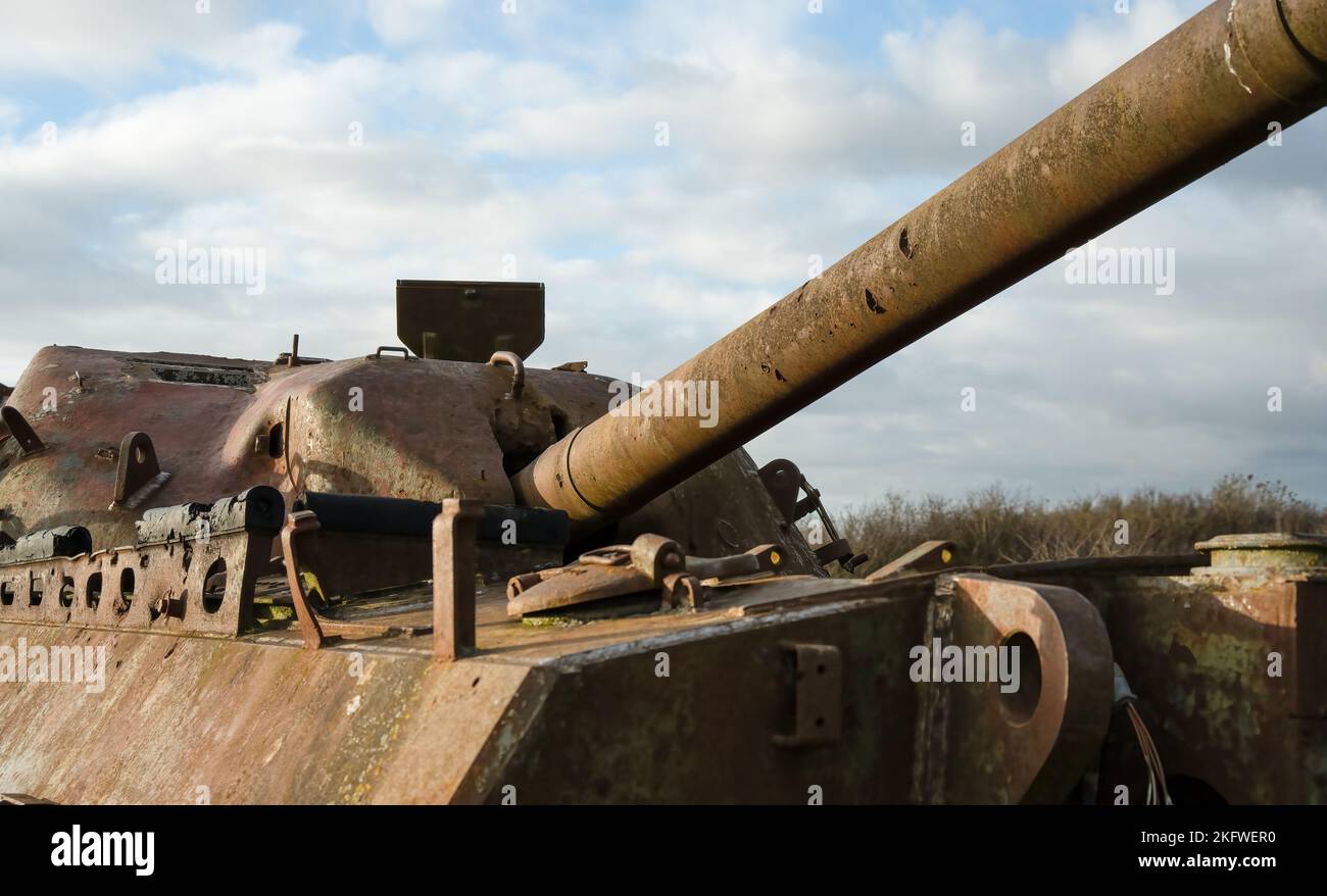 an abandoned rusting British FV4201 Chieftain main battle tank wreck in afternoon sunlight Stock Photo