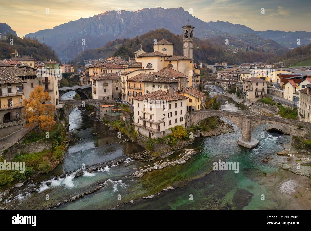 Aerial view of ancient church and crossing rivers surrounded by Alps mountains, San Giovanni Bianco Village, Valbrembana, Bergamo, Lombardy, Italy Stock Photo