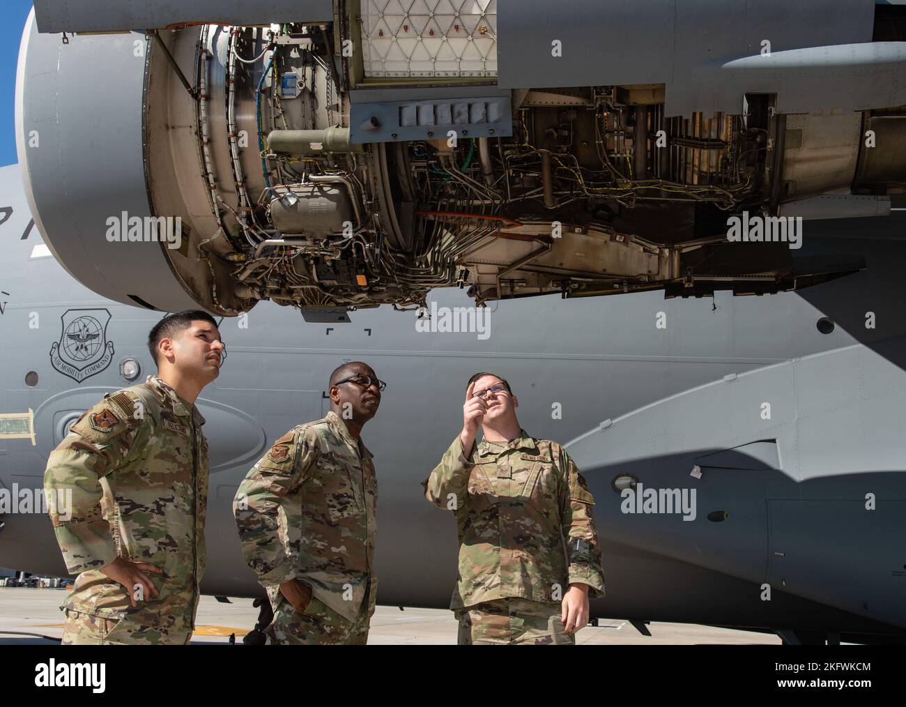 Staff Sgt. Robert Johnson, right, 736th Aircraft Maintenance Squadron C-17 Globemaster III crew chief, briefs Chaplain (Capt.) William Guy, center, 436th Airlift Wing chaplain and Tech. Sgt. Eric Feliciano, left, 512th AW religious affairs airman, on engine inspection areas during a 180-day home station check inspection being performed at Dover Air Force Base, Delaware, Oct. 11, 2022. During the Friends on the Flight Line visit, the Holy Roller van delivered drinks, sandwiches and snacks provided by the United Service Organizations, to aircraft maintainers in various squadrons under the 436th Stock Photo