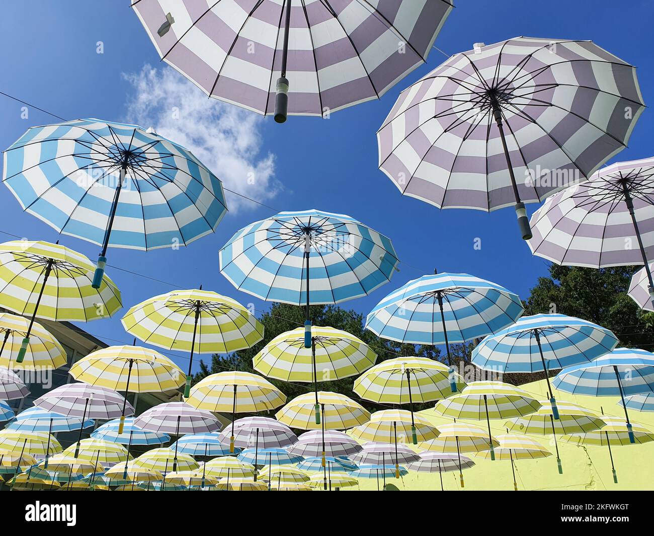 hanging colorful pastel tone umbrellas in the blue sky Stock Photo