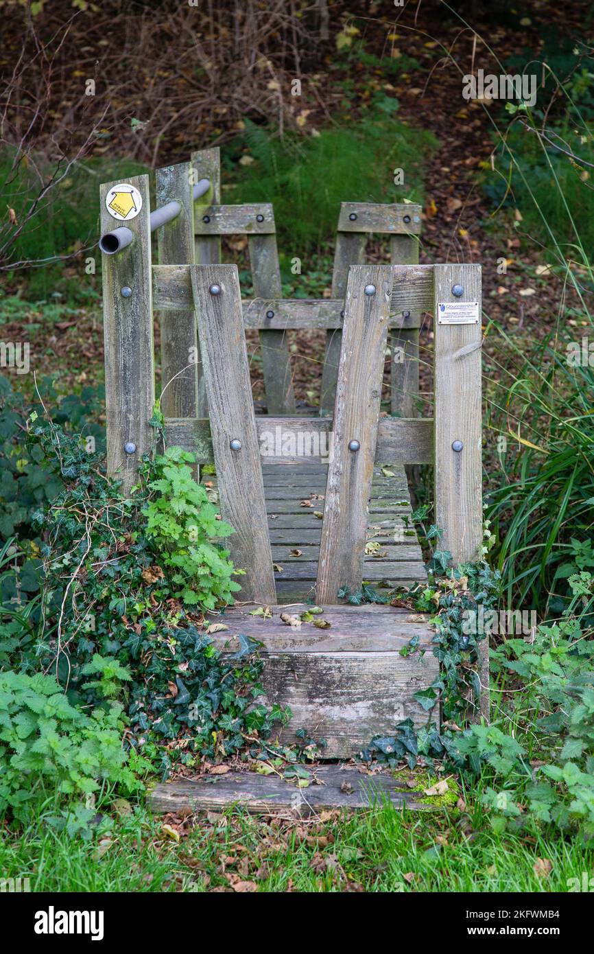 Pair of stiles at each end of a footbridge, Owlpen Monor Estate, Gloucestershire, England, UK. Stock Photo