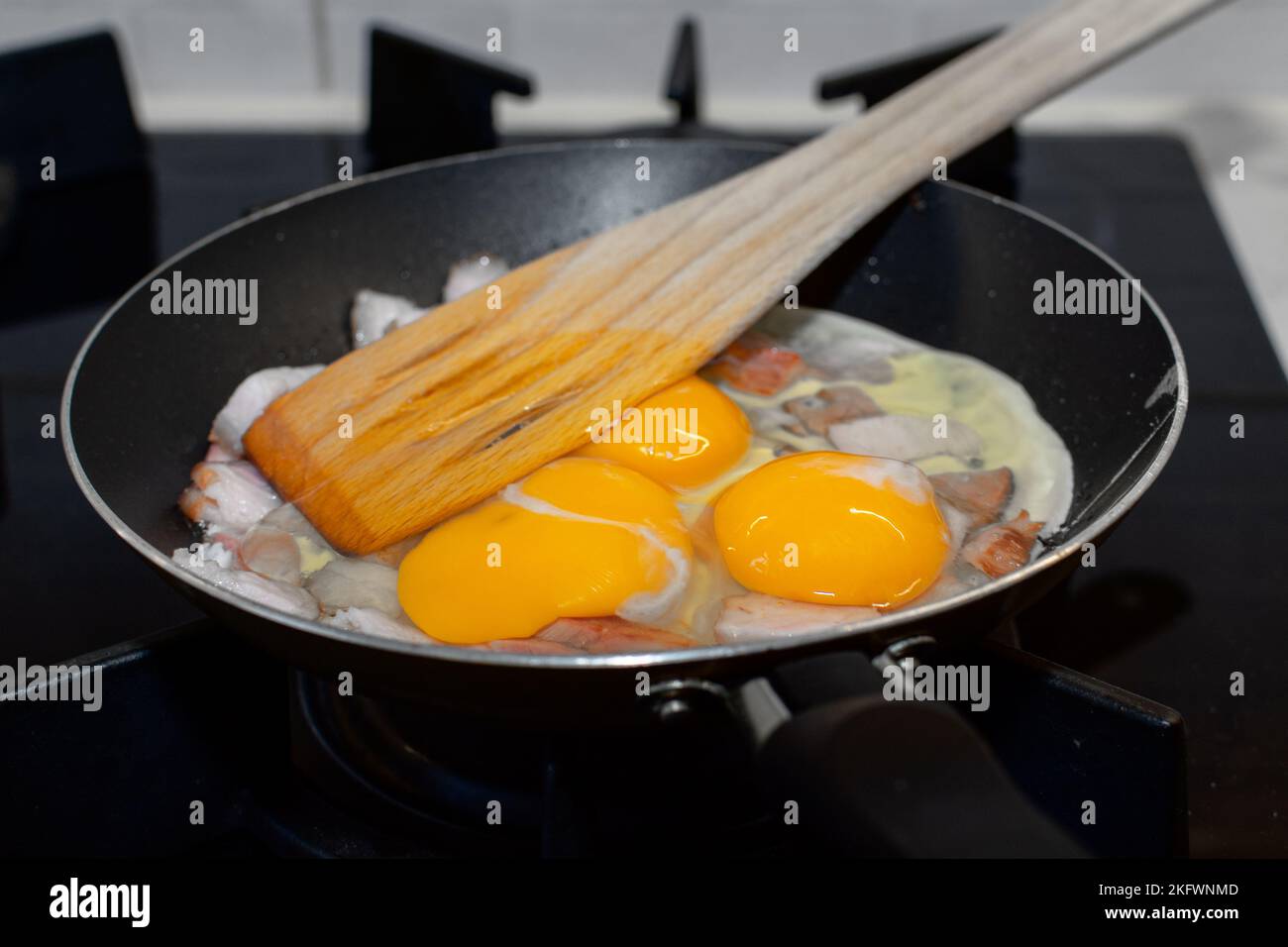 Scrambled eggs with bacon in a pan. Stock Photo
