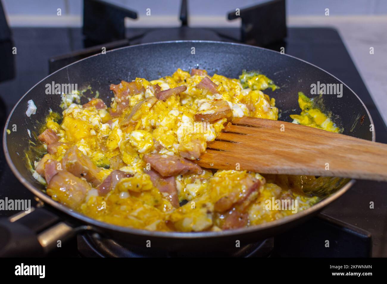 Scrambled eggs with bacon in a pan. Stock Photo
